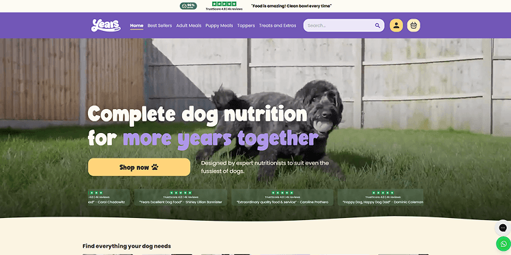 The Years.com shop homepage. A search-led nav across meals, toppers and treats, over a dog running in a garden.